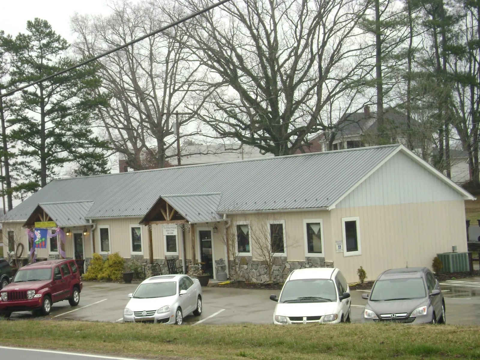 Gray metal roof with timber entry brackets on a small commercial building in Coleman