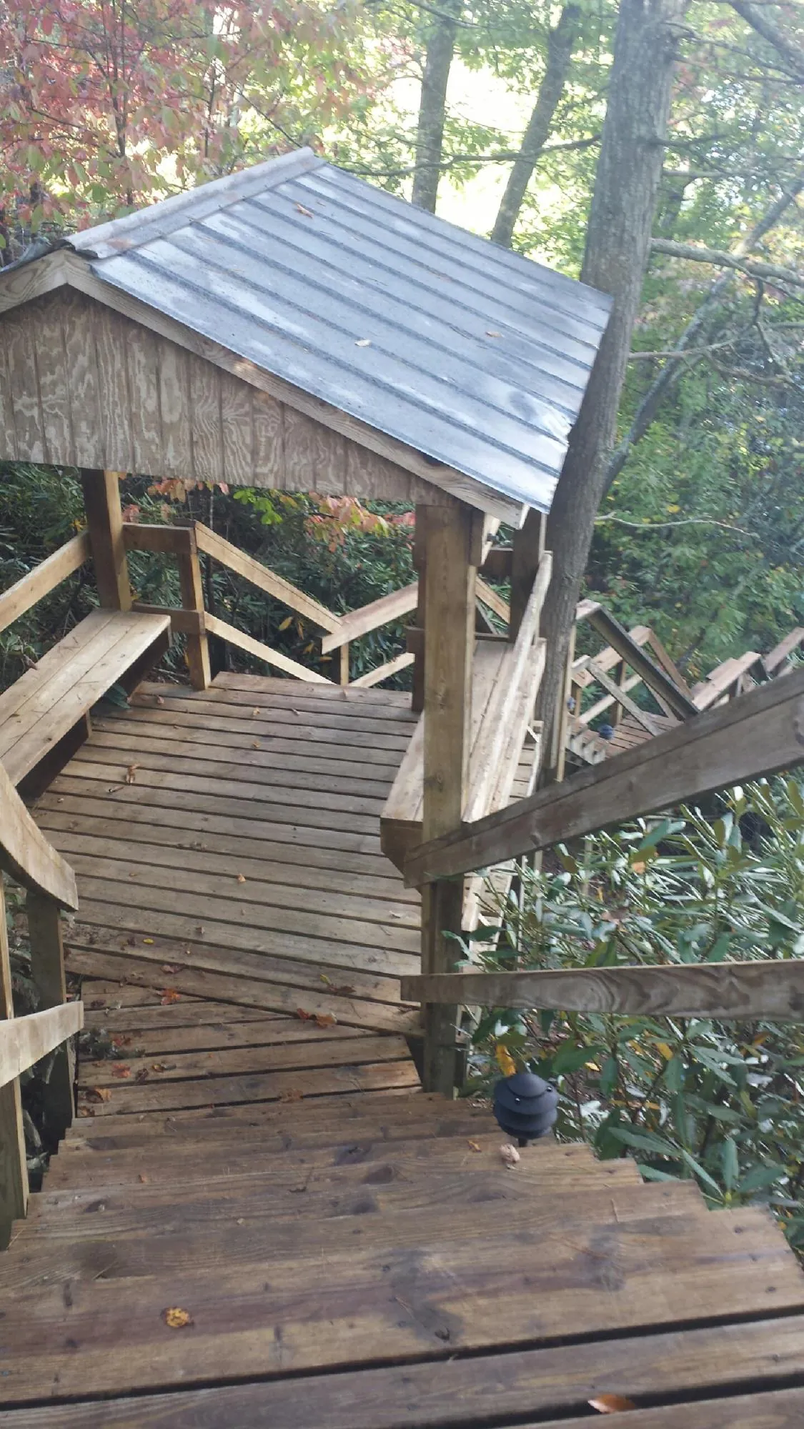 Metal roofed shelter over wooden steps on a wooded walkway — Skylight Repair & Installation work by our crew in Coleman